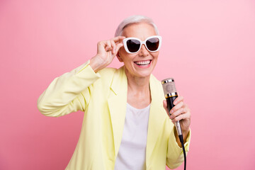 Portrait photo of cool woman wear yellow jacket touching sunglass singing microphone in karaoke...
