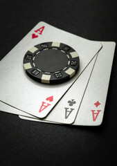 Poker game with three of a kind or set combination. Chip and playing cards on a black table in a poker club