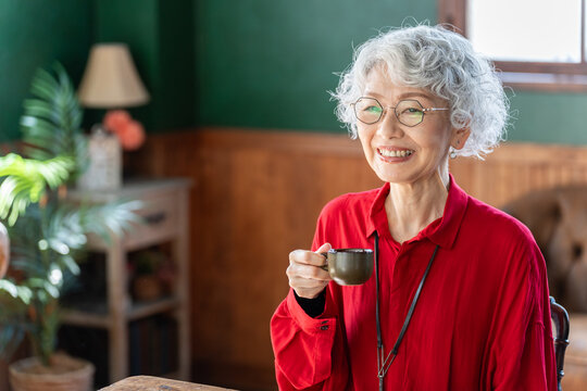 コーヒーを飲む笑顔のシニア女性