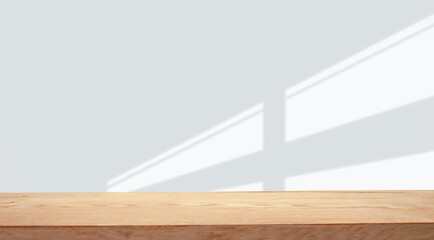 empty table with window shadow on light wall background for product mockup display. kitchen...