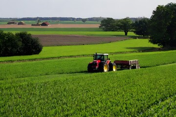 Fototapeta premium A farmer driving a tractor in a field