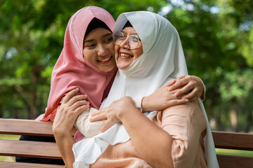 Muslim careful caregiver or nurse taking care of the patient in the hospital park. Happy Muslim...
