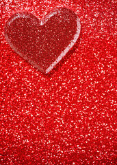 A backdrop with a close-up of a glittering red heart on a shimmering background, embodying the sparkle and excitement commonly associated with Valentine's Day.