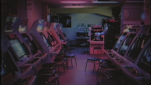 Vintage Arcade Gaming Lounge VHS Texture Tracking Shot. Walking through an old empty gaming lounge, vintage VHS texture. Tracking shot
