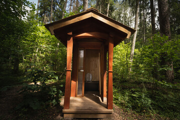 Fototapeta na wymiar Wooden toilet outdoors in the forest in Estonia in summer.