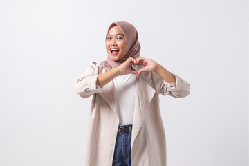Portrait of attractive Asian hijab woman in casual suit speaks about own feelings, makes heart...