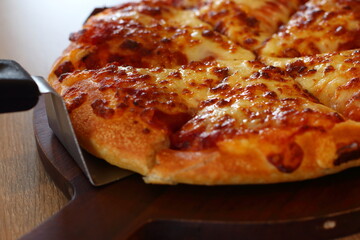 Double cheese pizza on a wooden plate