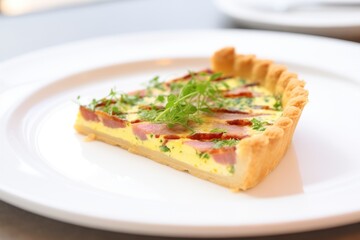 whole quiche lorraine on a white plate, garnished with parsley