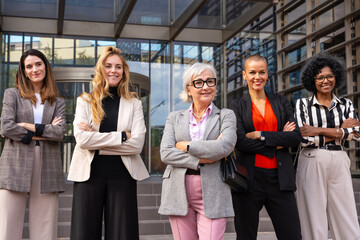  Team of multiracial diverse businesswomen led by smiling boss posing for camera.