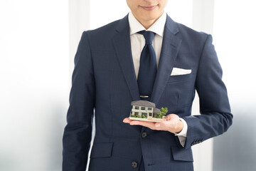一軒家の不動産をお勧めするビジネスマン