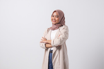 Fototapeta premium Portrait of young successful Asian hijab woman in casual suit looking at camera, holding hands crossed folded. Isolated image on white background