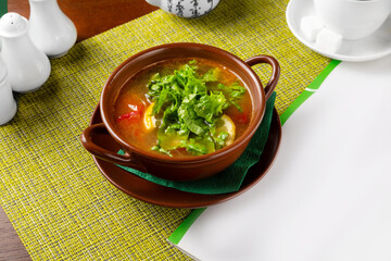 Soup with tomato, lemon and lettuce. Lunch.