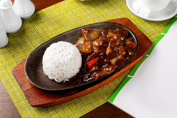 Fried lamb in a frying pan with rice. Lunch.