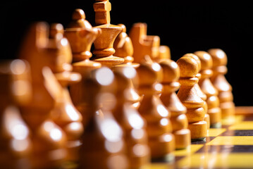 Chess pieces,beautiful old chess pieces on a board, black background, selective focus.