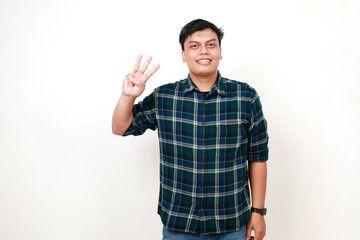 Happy young adult Indonesian man standing while showing three fingers. Isolated on white