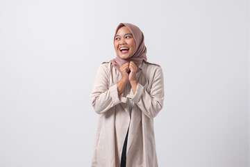 Portrait of young successful Asian hijab woman in casual suit looks happy and smiling while folding...