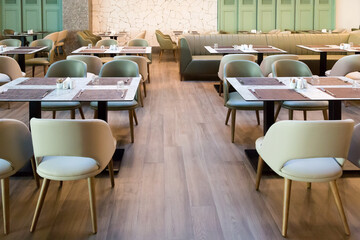 Interior of a restaurant hall wooden floor, furniture and people.