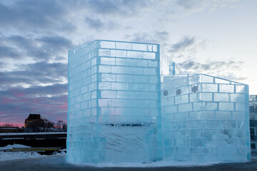 Detail of the ice palace in construction for the annual winter festival seen at sunrise, with old...