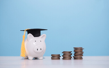 Piggy bank with graduation hat and stack of coins. The concept of saving money for education,...