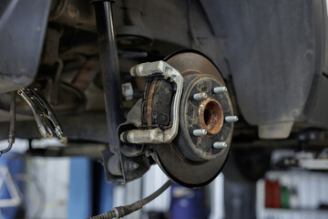 Fototapeta premium Replacement of rear and front brake pads in a car service station.