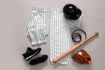 Baseball uniform and other sports equipment on white background, flat lay