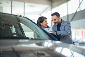 Cute couple peering into a car at a dealer while deciding whether to buy. Spouses Looking At Car Interior Buying Vehicle In Store. We should organise a test drive