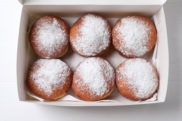 Delicious sweet buns in box on table, top view