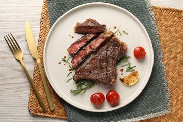 Delicious grilled beef steak served on light wooden table, top view