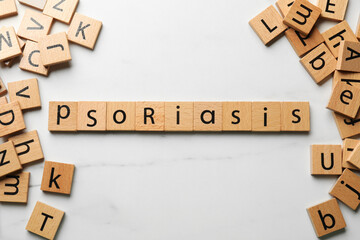 Word Psoriasis made of wooden squares with letters on white table, flat lay