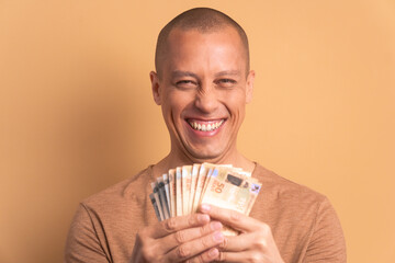 fun bald man with brazil banknotes currency in beige colors. app, social media, connection concept.