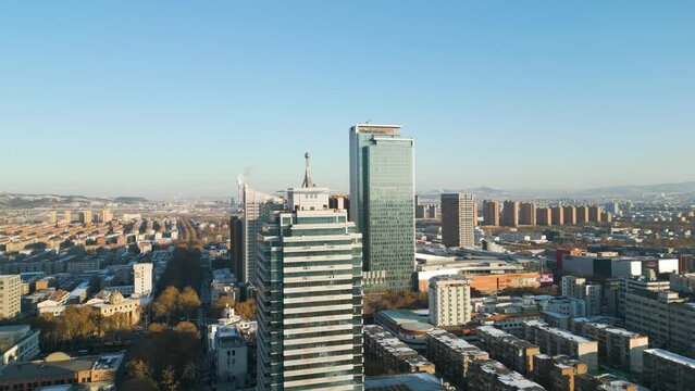 Ascending aerial during the sunshine day in Zibo City, Shandong Province, China. Showcasing Ramada and Sheraton Hotels, with power plants visible in the backdrop.