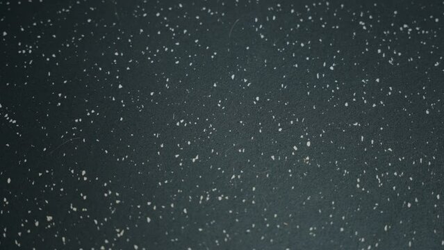 Panning 4K Shot of a Black and White Speckled Rubber Gym Workout Home Floor with Locking Grooves Inside