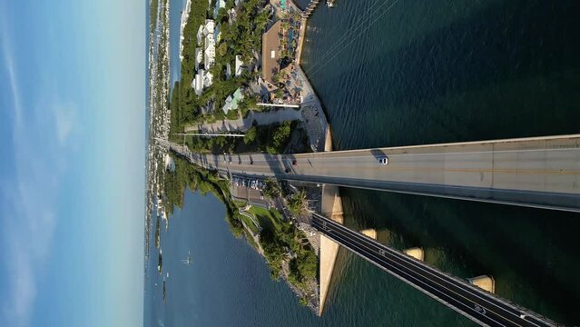 Drone shot of a car driving through the famous 7-mile bridge in the Florida Keys.