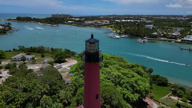 Drone shot of the Jupiter Lighthouse in Florida as boats pass by in the ocean.