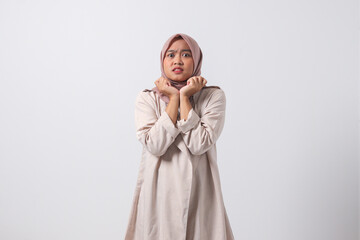 Portrait of frightened Asian hijab woman in casual suit making shocked hand gesture, showing surprised and scared expression. Isolated image on white background
