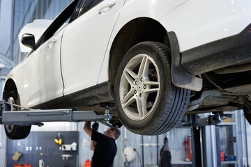 Repair of cars, chassis, automatic transmission and engine in an auto repair shop or garage. The car is lifted on a lift.