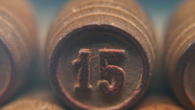 Cinematic macro smooth shot of Bingo wooden barrels in a row, woody figures, old numbers vintage board game, lucky number 15, slow motion, 4K commercial gimbal movement, dreamy lighting, tilt up