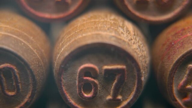 Cinematic macro smooth shot of Bingo wooden barrels in a row, woody figures, old numbers vintage board game, lucky number 67, slow motion, 4K commercial gimbal movement, dreamy lighting, tilt up