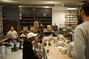 Group of ceramic studio workers having a meeting together