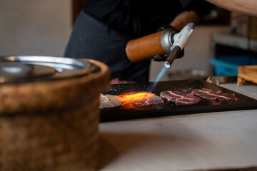 Grilling beef slices with fire-canned gas on the table, Japanese food, Street food in Thailand. - obrazy, fototapety, plakaty