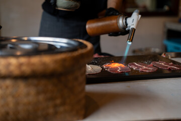 Grilling beef slices with fire-canned gas on the table, Japanese food, Street food in Thailand.