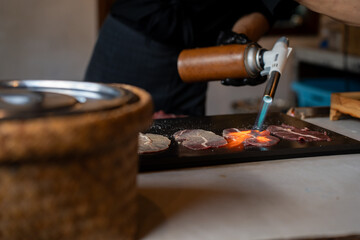Grilling beef slices with fire-canned gas on the table, Japanese food, Street food in Thailand.