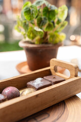 Chocolates candy of various flavors and types in wooden trays are served on the table. Sweet food.
