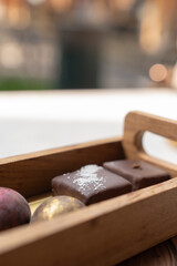 Chocolates candy of various flavors and types in wooden trays are served on the table. Sweet food.