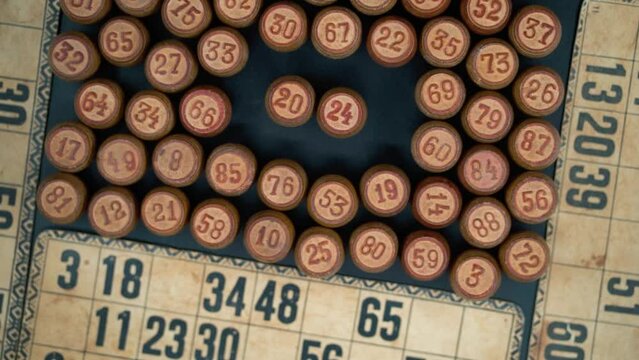 Cinematic close-up smooth shot from above of a pile of Bingo wooden barrels in a square, woody figures, old numbers background, vintage board game, slow motion 120 FPS commercial rotating gimbal video