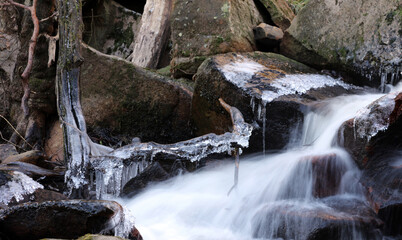 Dead branch covered in ice over a winter stream, Derbyshire England
