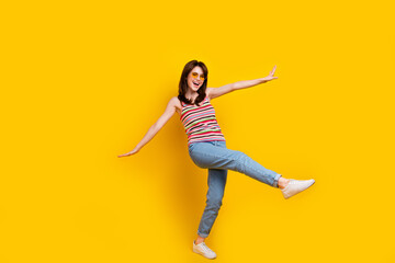 Fototapeta na wymiar Full size photo of cute woman dressed knitwear top jeans pants in sunglass hands wings fooling around isolated on yellow color background