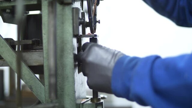 A worker using a machine to drill into a metal piece.