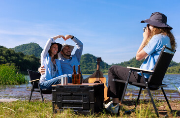 Fototapeta premium happy family daughter takes pictures for mom and dad at the campground by the riverside,