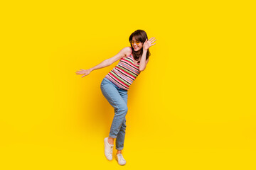 Fototapeta na wymiar Full size photo of girlish cheerful woman dressed knitwear top jeans pants in sunglass dancing isolated on yellow color background